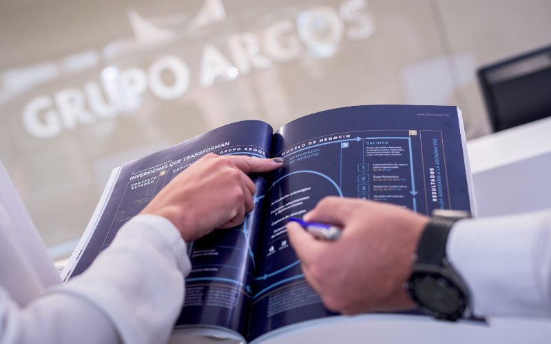 Dos manos sosteniendo una revista de Grupo Argos